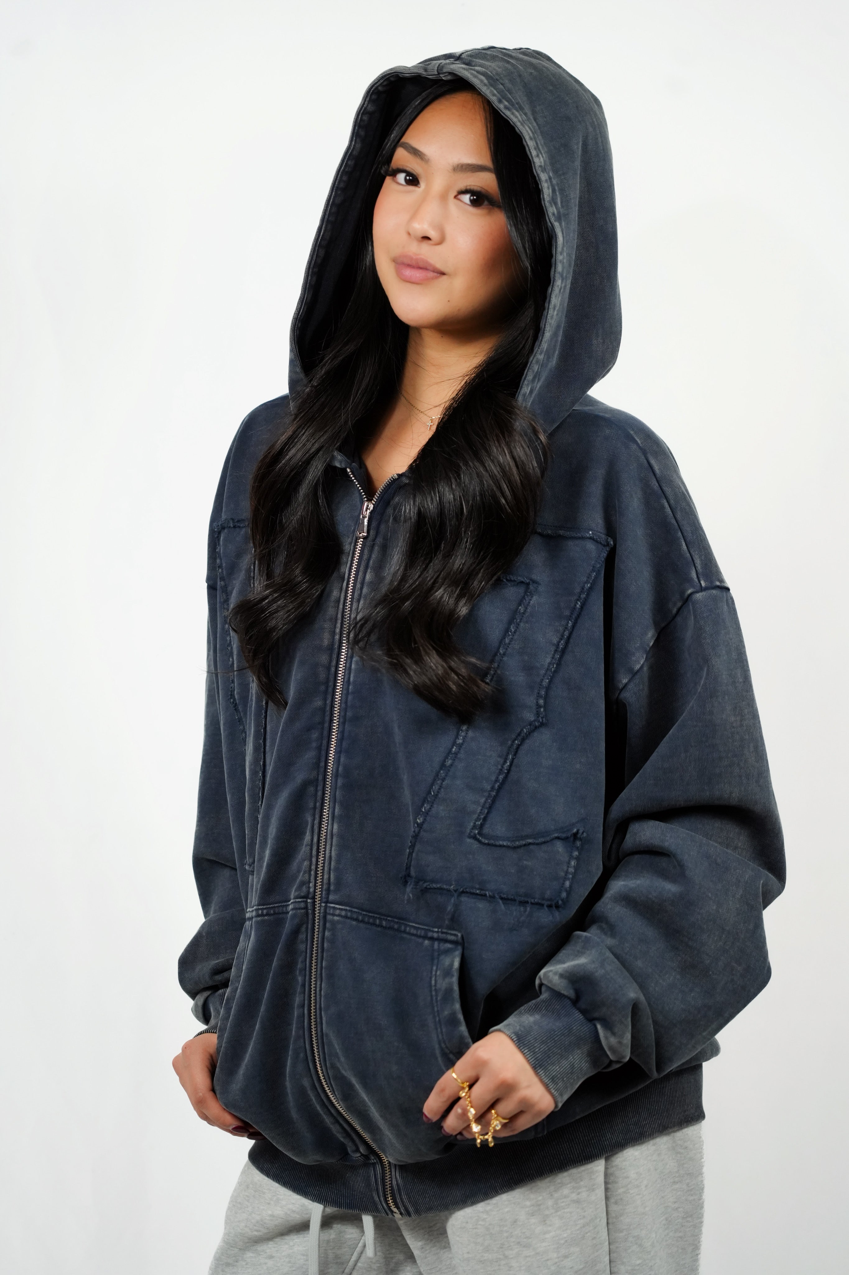 Person wearing a dark hoodie on a white background