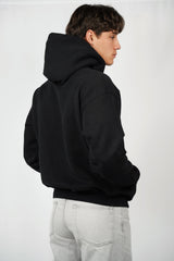 Person wearing a black hoodie from behind on a white background