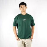 Person wearing a green t-shirt with a logo on a white background