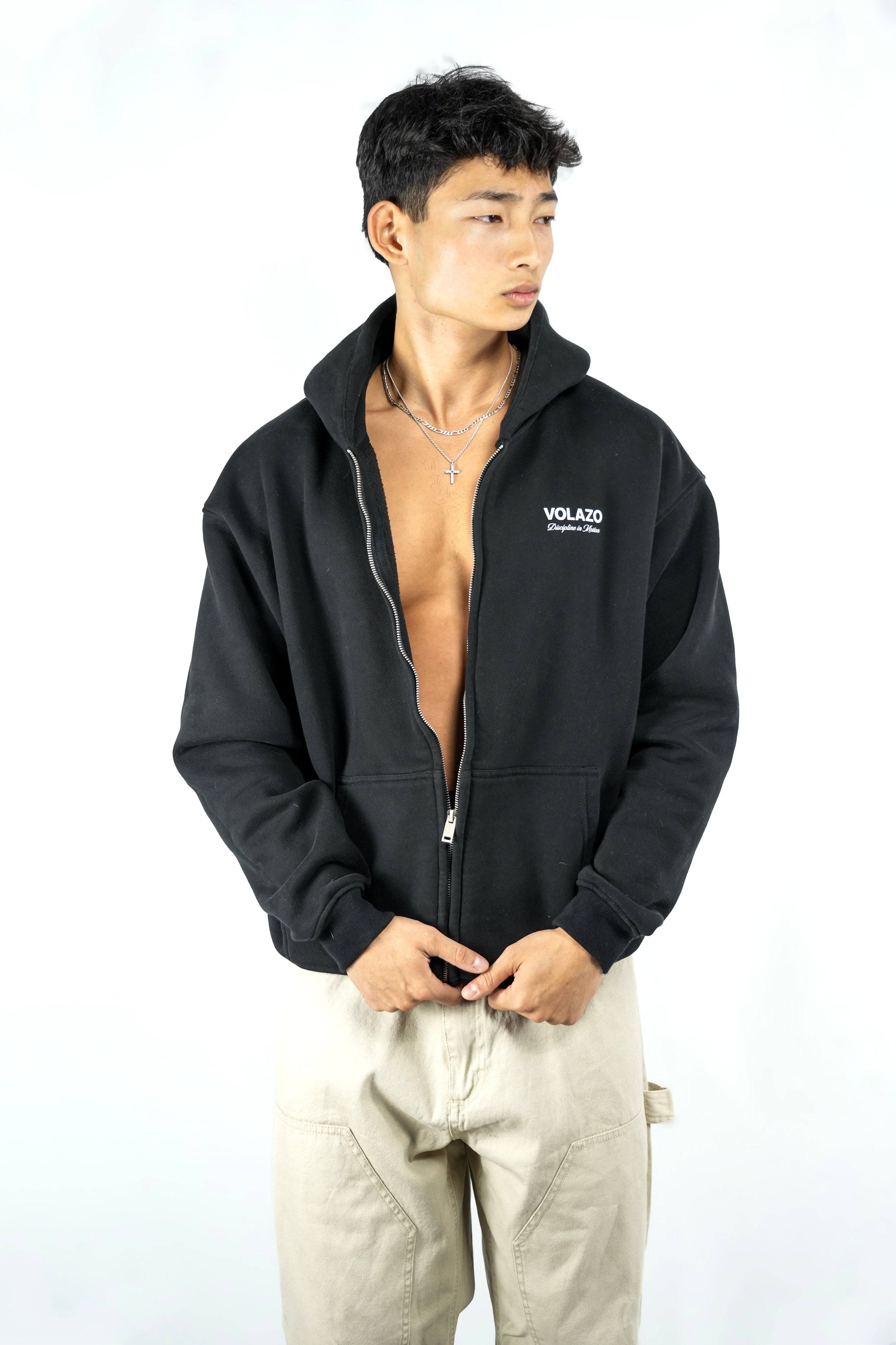 Person wearing a black hoodie with a visible brand logo on a white background